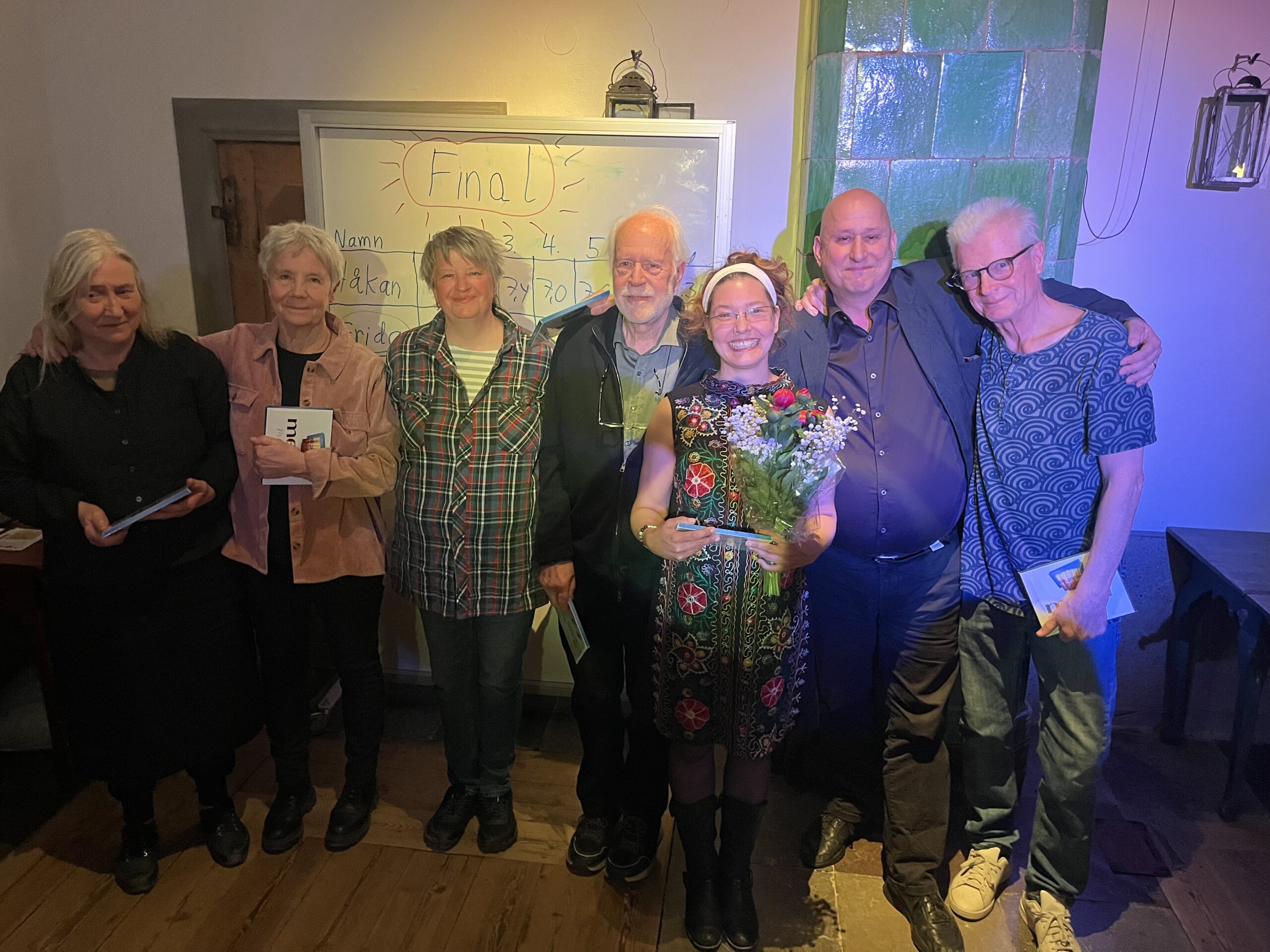 Deltagarna under Berättarslammet uppradade i Källarstugan. Vinnaren Frida Spång har blombukett